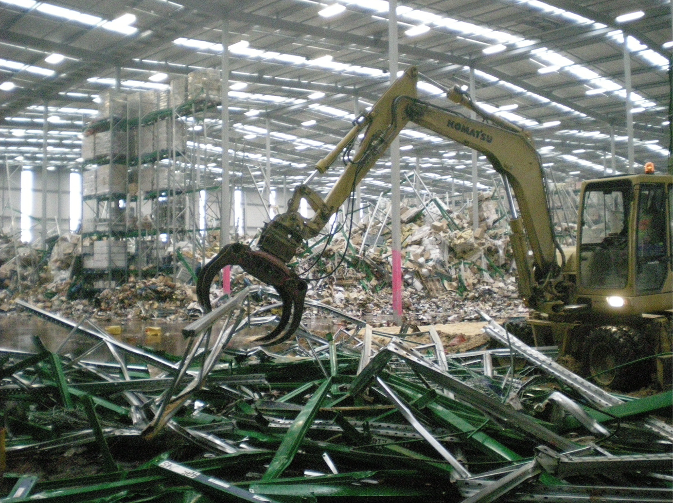 christchurch-earthquake-excavator-claw-picking-up-racking-in-warehouse-96dpi.png